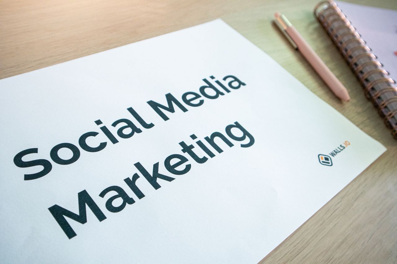 services-02 Close view of a social media marketing document on a desk with a pen and notebook.